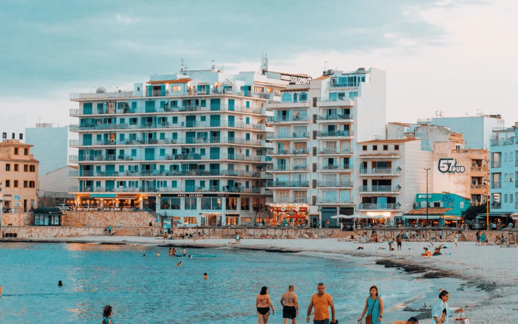 Playa urbana con bañistas y edificios frente al mar.
